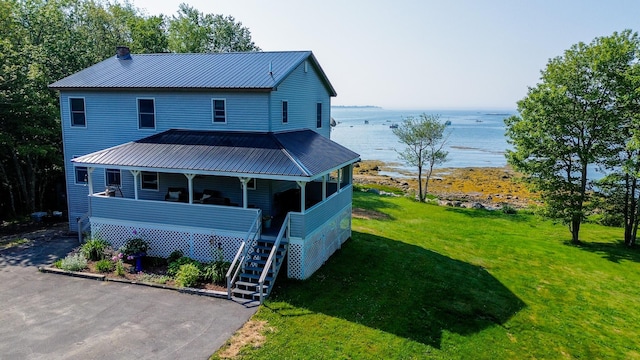 119 Merritt Rd, Steuben, ME 04680 - view of front of house featuring a water view, a front yard, a metal roof, and a porch