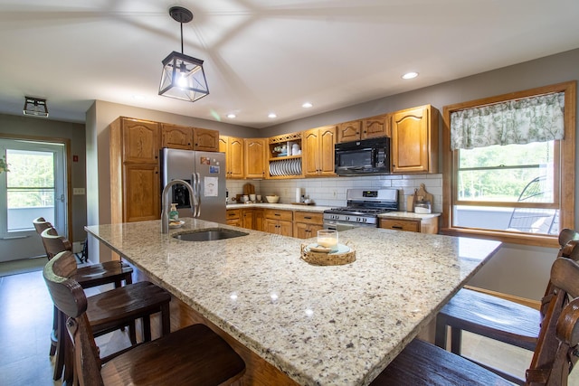 119 Merritt Rd, Steuben, ME 04680 - kitchen featuring stainless steel appliances, backsplash, light stone countertops, a kitchen bar, and recessed lighting