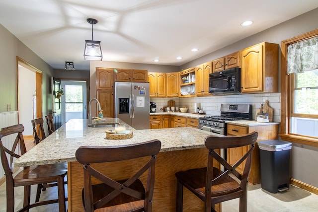 119 Merritt Rd, Steuben, ME 04680 - kitchen featuring stainless steel appliances, tasteful backsplash, light stone countertops, pendant lighting, and a kitchen bar