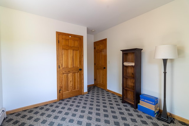 119 Merritt Rd, Steuben, ME 04680 - unfurnished bedroom with a baseboard heating unit and dark carpet