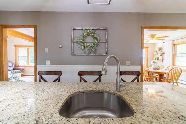 119 Merritt Rd, Steuben, ME 04680 - kitchen featuring a wainscoted wall, light stone counters, and baseboard heating