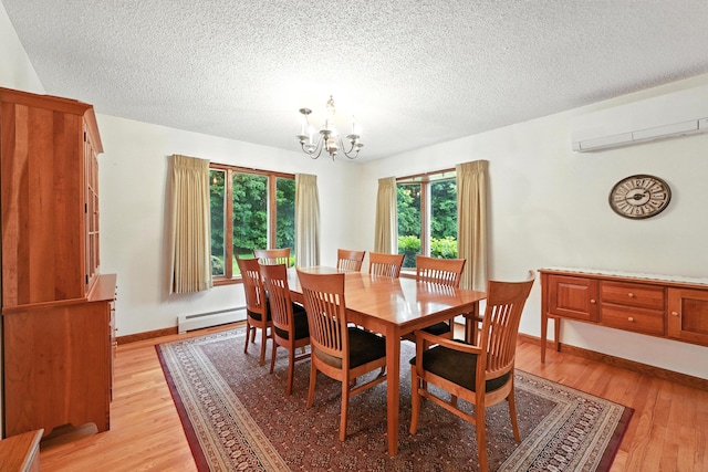 3 Tallwood Rd, Augusta, ME 04330 - dining room with baseboard heating, a wall unit AC, a chandelier, light wood finished floors, and a textured ceiling