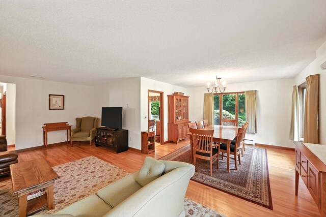 3 Tallwood Rd, Augusta, ME 04330 - living room with a chandelier, light wood-type flooring, baseboard heating, and a textured ceiling