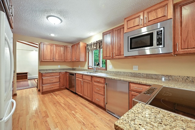 3 Tallwood Rd, Augusta, ME 04330 - kitchen featuring stainless steel appliances, light wood-style flooring, a textured ceiling, brown cabinets, and recessed lighting