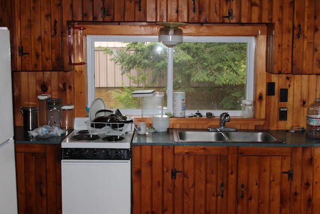 8 Drake Ln, Oakfield, ME 04763 - kitchen with white appliances, brown cabinetry, plenty of natural light, and wood walls