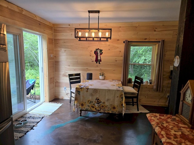 340 Campground Rd, Anson, ME 04958 - dining space featuring concrete flooring, plenty of natural light, wood walls, and a chandelier