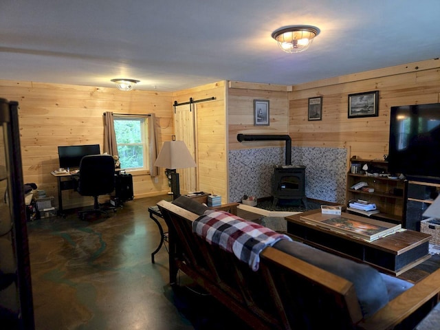 340 Campground Rd, Anson, ME 04958 - living area with finished concrete flooring, wood walls, a wood stove, a barn door, and an office area