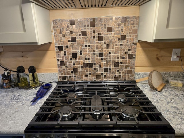 340 Campground Rd, Anson, ME 04958 - kitchen view of backsplash, white cabinets, range, and light stone counters