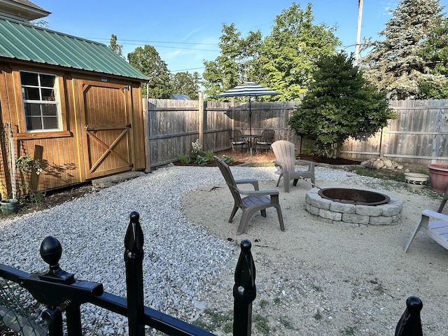 72 Federal Rd, Parsonsfield, ME 04047 - fenced backyard with an outdoor fire pit, a storage unit, and a patio area