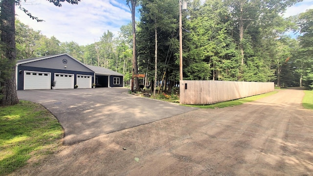 62 Cobb Rd, Stetson, ME 04488 - view of side of home featuring driveway, an attached garage, and a forest view