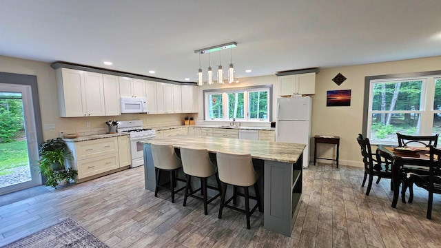 62 Cobb Rd, Stetson, ME 04488 - kitchen featuring white appliances, healthy amount of natural light, wood finished floors, a center island, and recessed lighting