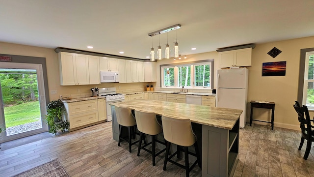 62 Cobb Rd, Stetson, ME 04488 - kitchen featuring white appliances, a kitchen island, wood finished floors, light stone countertops, and recessed lighting