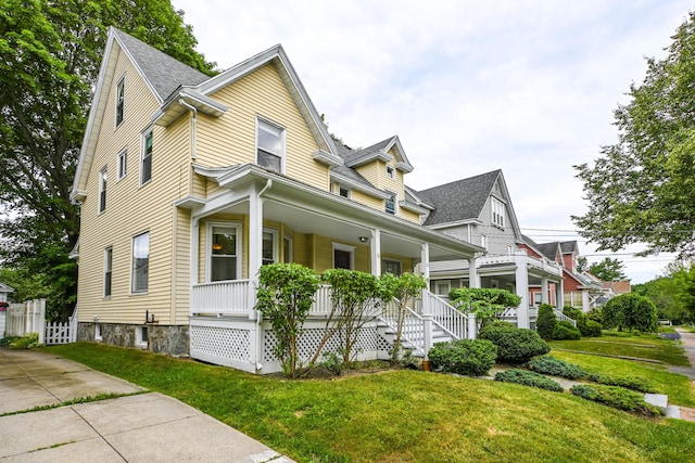 18 Colonial Rd Unit 18, Portland, ME 04102 - view of side of home featuring covered porch, a yard, and a shingled roof