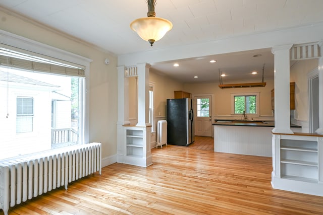18 Colonial Rd Unit 18, Portland, ME 04102 - kitchen featuring radiator, refrigerator with ice dispenser, decorative columns, light wood-style floors, and ornamental molding