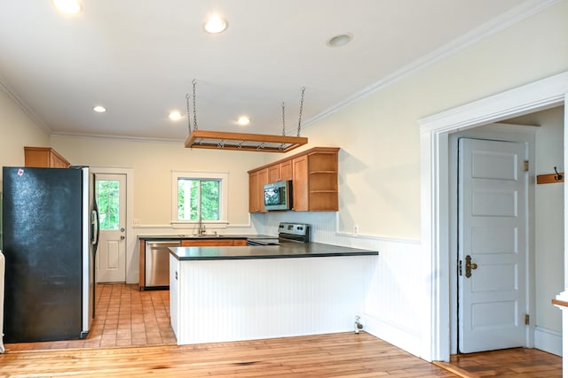 18 Colonial Rd Unit 18, Portland, ME 04102 - kitchen with stainless steel appliances, a peninsula, open shelves, wainscoting, and crown molding