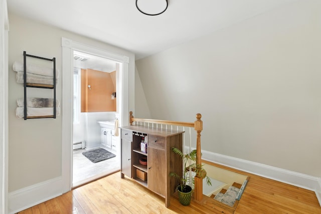 214 S Main St, Auburn, ME 04210 - hall featuring a baseboard radiator, light wood-style floors, and an upstairs landing