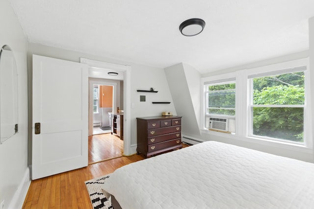214 S Main St, Auburn, ME 04210 - bedroom with baseboard heating, light wood-style flooring, cooling unit, and a baseboard heating unit