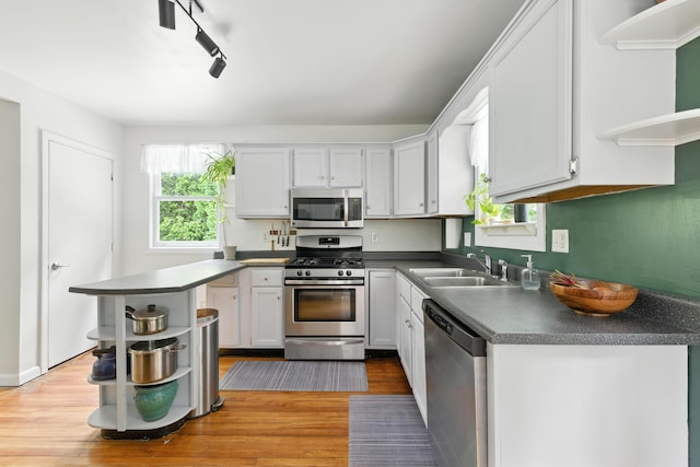 214 S Main St, Auburn, ME 04210 - kitchen with stainless steel appliances, open shelves, light wood-style flooring, and dark countertops