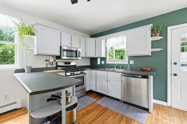 214 S Main St, Auburn, ME 04210 - kitchen featuring appliances with stainless steel finishes, open shelves, baseboard heating, and dark countertops