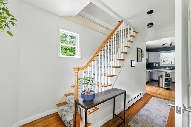 214 S Main St, Auburn, ME 04210 - staircase featuring a baseboard radiator, hardwood / wood-style flooring, and plenty of natural light