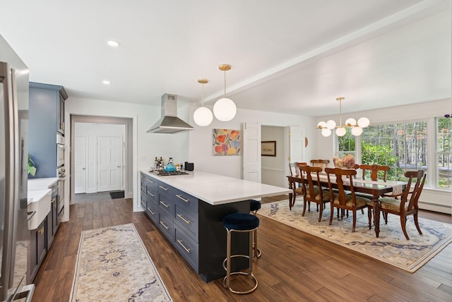 6 Beechwood Ln, Falmouth, ME 04105 - kitchen featuring wall chimney exhaust hood, a breakfast bar, light countertops, dark wood-type flooring, and recessed lighting