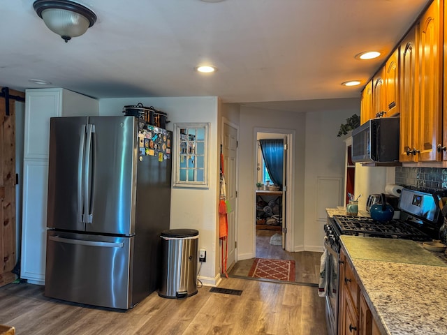 27 Main St, Vassalboro, ME 04989 - kitchen featuring stainless steel appliances, brown cabinets, wood finished floors, light countertops, and recessed lighting