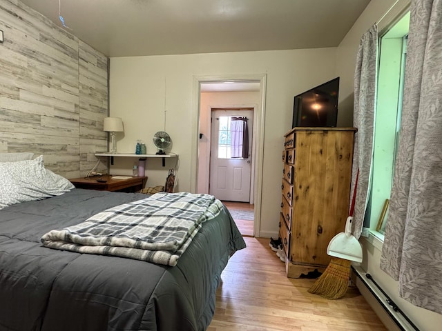 27 Main St, Vassalboro, ME 04989 - bedroom with wooden walls, wood finished floors, and a baseboard heating unit