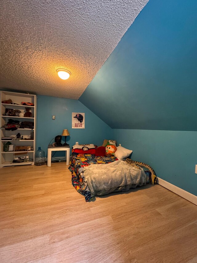 27 Main St, Vassalboro, ME 04989 - bedroom with wood finished floors, a textured ceiling, and vaulted ceiling
