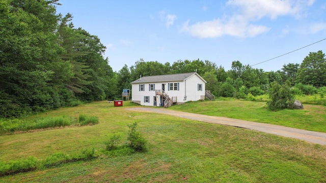 32 Barton Rd, Windsor, ME 04363 - view of front facade featuring a front lawn, driveway, and a wooded view