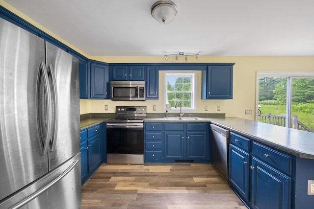 32 Barton Rd, Windsor, ME 04363 - kitchen with stainless steel appliances, a peninsula, blue cabinets, and light wood-type flooring