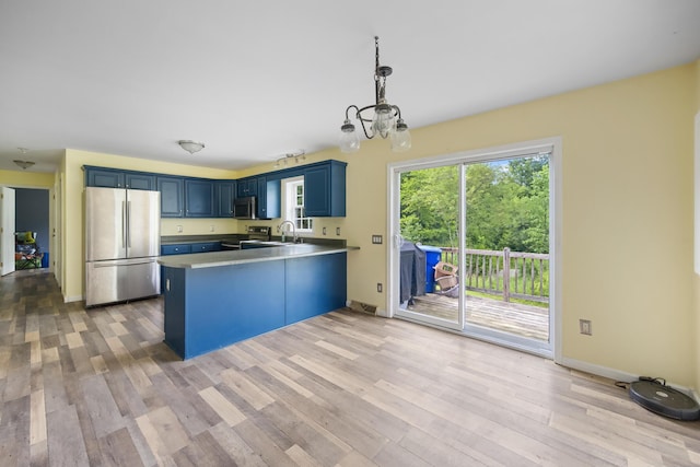 32 Barton Rd, Windsor, ME 04363 - kitchen with appliances with stainless steel finishes, blue cabinets, a peninsula, and light wood-style floors