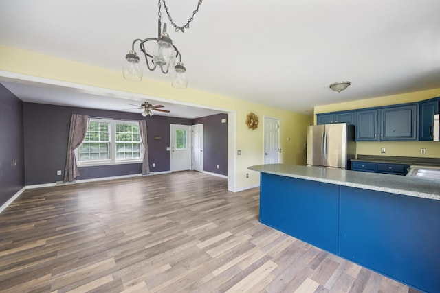 32 Barton Rd, Windsor, ME 04363 - kitchen featuring freestanding refrigerator, wood finished floors, blue cabinetry, a peninsula, and a ceiling fan