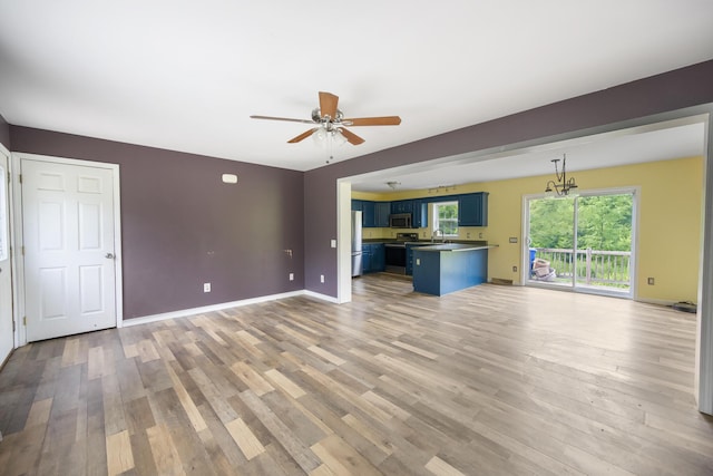 32 Barton Rd, Windsor, ME 04363 - unfurnished living room featuring a ceiling fan, light wood-style floors, and a chandelier