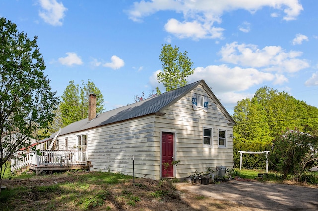 138 Main St, Brownfield, ME 04010 - view of side of home with a metal roof, a wooden deck, and a chimney