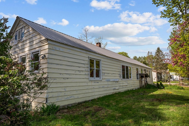 138 Main St, Brownfield, ME 04010 - view of property exterior featuring a metal roof, a yard, and a chimney