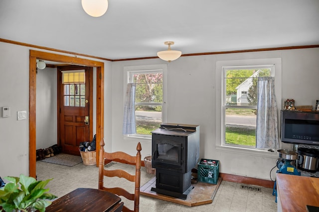 138 Main St, Brownfield, ME 04010 - foyer featuring a wood stove, healthy amount of natural light, and crown molding