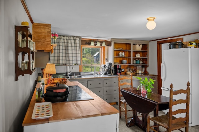 138 Main St, Brownfield, ME 04010 - kitchen with freestanding refrigerator, open shelves, cooktop, and wood counters