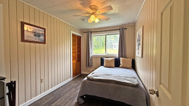 585 N Lubec Rd, Lubec, ME 04652 - bedroom with wooden walls, dark wood finished floors, ornamental molding, a closet, and ceiling fan