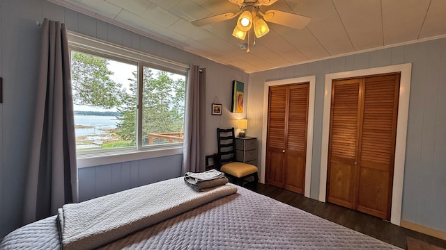 585 N Lubec Rd, Lubec, ME 04652 - bedroom featuring two closets, dark wood-type flooring, multiple windows, ornamental molding, and ceiling fan