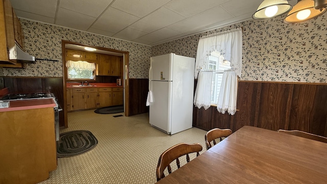 269 County Rd, Lubec, ME 04652 - kitchen with wallpapered walls, a wainscoted wall, freestanding refrigerator, plenty of natural light, and gas range