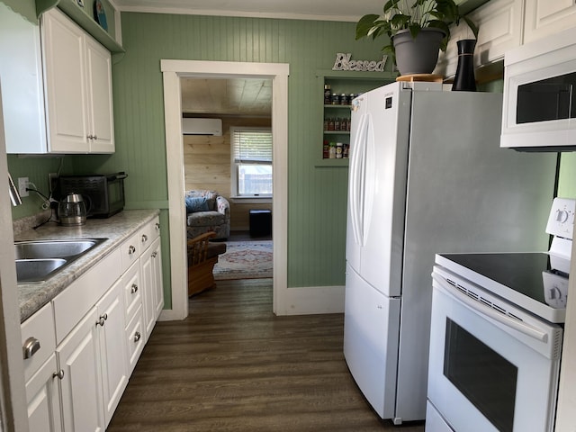48 Dane Ave, Skowhegan, ME 04976 - kitchen featuring white appliances, dark wood-style flooring, white cabinets, a wall mounted air conditioner, and wooden walls