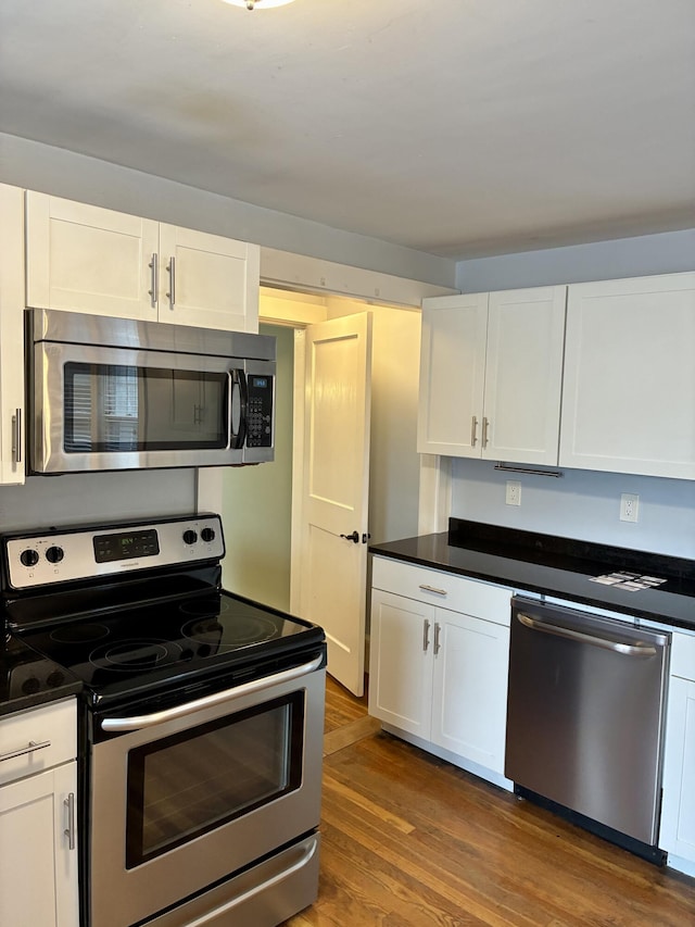 272 Center St, Bangor, ME 04401 - kitchen with appliances with stainless steel finishes, white cabinets, dark wood-style floors, and dark countertops