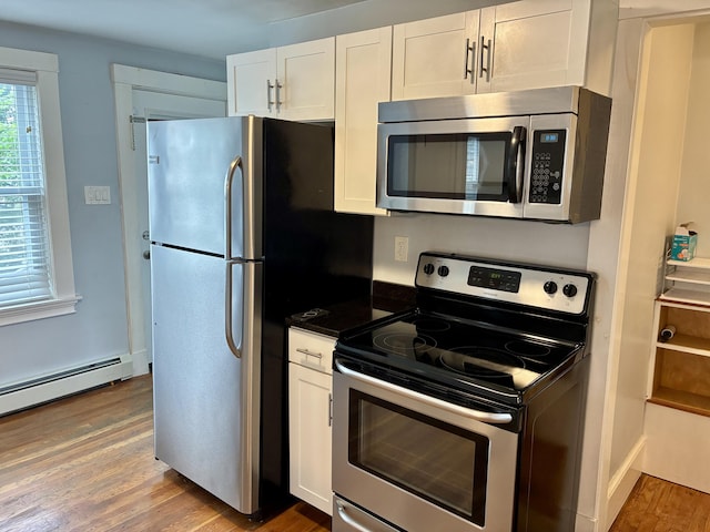 272 Center St, Bangor, ME 04401 - kitchen featuring stainless steel appliances, white cabinets, light wood-style flooring, dark countertops, and a baseboard radiator