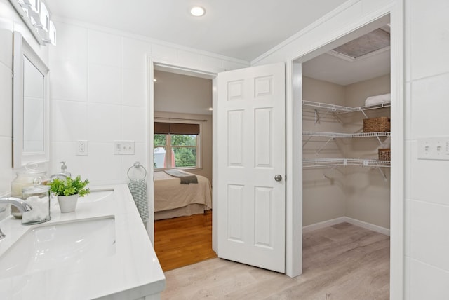 471 Methodist Rd, Westbrook, ME 04092 - ensuite bathroom featuring double vanity, wood finished floors, a walk in closet, recessed lighting, and crown molding