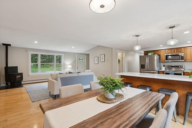 471 Methodist Rd, Westbrook, ME 04092 - dining area with recessed lighting, light wood finished floors, a wood stove, and a baseboard heating unit