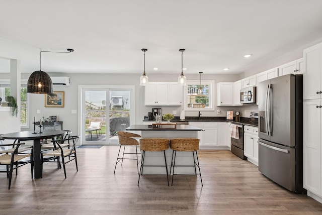 37 Homewood Blvd, Old Orchard Beach, ME 04064 - kitchen with appliances with stainless steel finishes, a breakfast bar area, dark countertops, white cabinetry, and recessed lighting