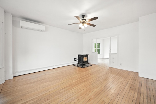 38 Silvermount St, Waterville, ME 04901 - unfurnished living room featuring a wood stove, a wall mounted air conditioner, a baseboard radiator, a ceiling fan, and wood-type flooring