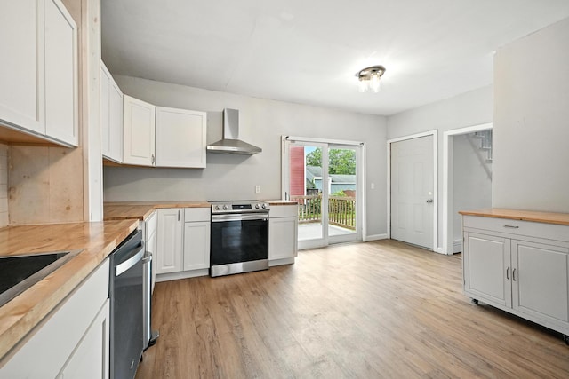 38 Silvermount St, Waterville, ME 04901 - kitchen featuring wall chimney range hood, appliances with stainless steel finishes, white cabinetry, and light wood-type flooring