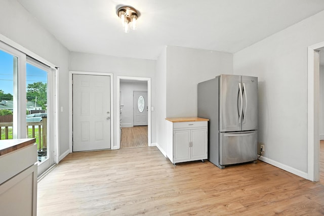 38 Silvermount St, Waterville, ME 04901 - kitchen with freestanding refrigerator, light wood-style floors, and white cabinetry