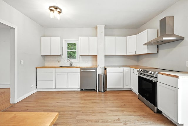 38 Silvermount St, Waterville, ME 04901 - kitchen featuring wall chimney range hood, stainless steel appliances, light wood finished floors, and backsplash
